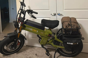 Aniioki A8 Pro army green electric bicycle storage inside a modern apartment hallway, showcasing the heavy-duty e-bike parked safely indoors next to a white closet door.